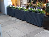 Block style trough wooden planters with spaces between the rows painted with Cuprinol's Urban Slate