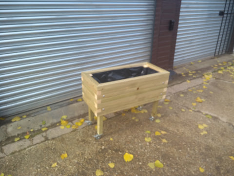 Block style raised wooden planters on casters / wheels and varnished