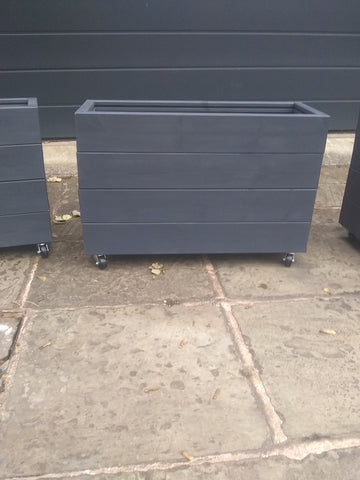 Smooth trough wooden planters with 4 rows of planks on wheels, painted with Cuprinol's Urban Slate